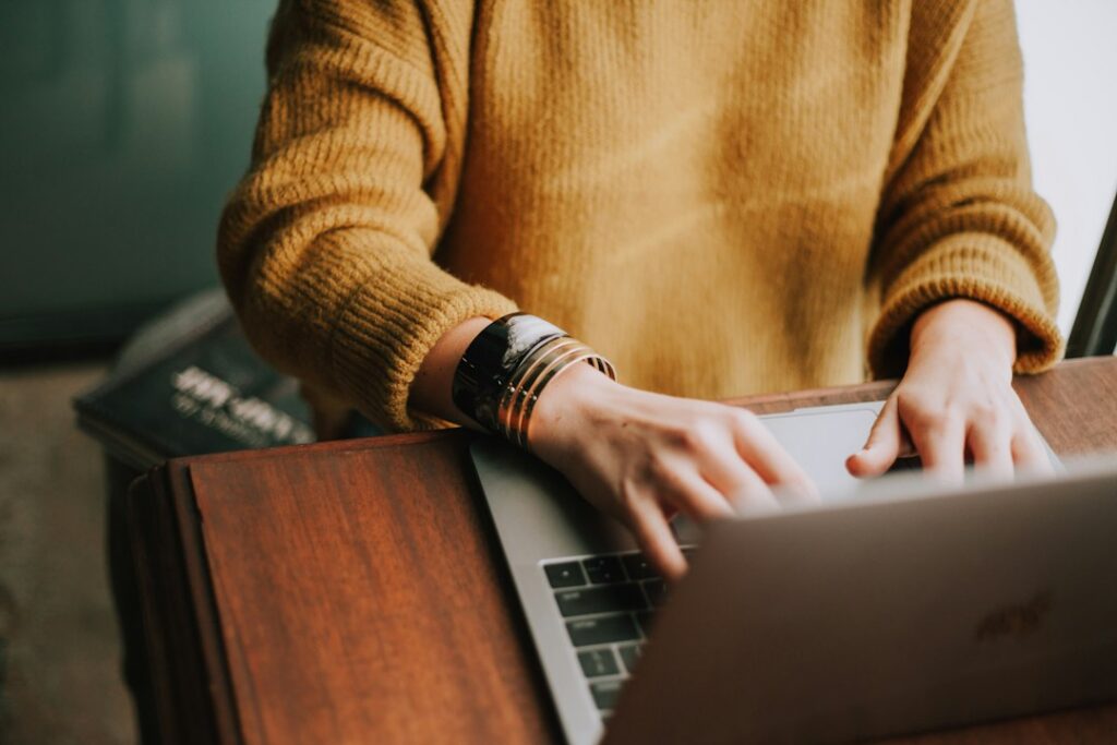A person typing on a laptop, illustrating the everyday interactions shaped by accessibility in digital design.