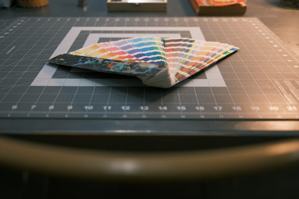 Fanned-out Pantone color swatches on a design cutting mat, representing early accessibility decisions in choosing a color palette.