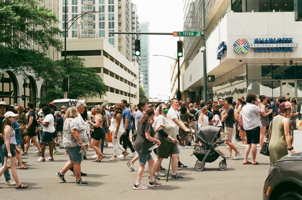 Diverse crowd of pedestrians crossing a busy city street, illustrating why accessibility matters for everyday public life.