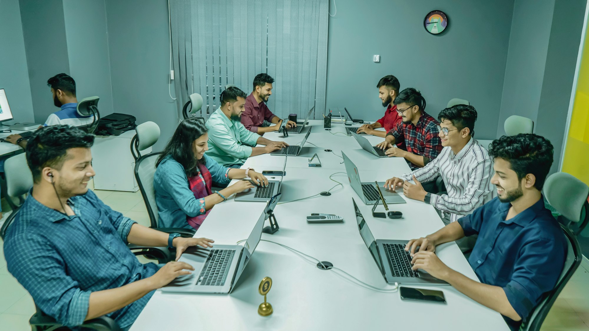 Team of engineers working together on laptops in an office